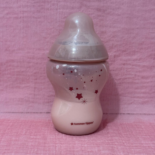 Baby bottle with star pattern on a pink background